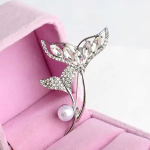 Exquisite silver-tone fish tail pearl brooch with sparkling crystals, elegant clothing accessory.