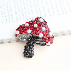 Prachtige champignon broche detailfoto met rode en zwarte strass steentjes en parels.