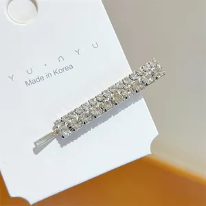 Close-up detail of sparkling double-row rhinestone hairpin metal hair clip on white display card