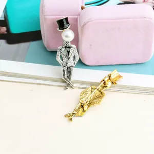 Élégante broche en forme de gentleman avec tête de perle et détails en zircone cubique.
