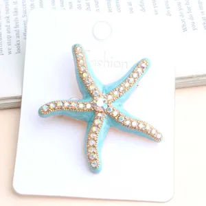 Starfish rhinestone brooch detail shot, blue enamel alloy jewelry accessory on white card.