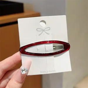 Red enamel cutout oval hair clip detail view, simple and elegant side hairpin for bangs.