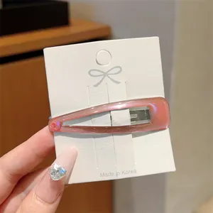 Detailed close-up view of minimalist pink resin hollow oval hair clip on display card.