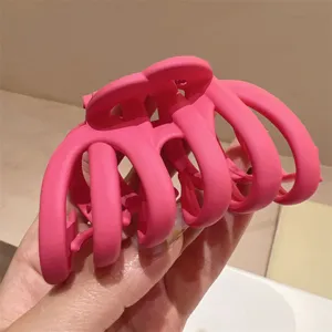 Vista detallada de una pinza de pelo rosa mate, gran accesorio para cabello abundante.