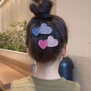 Detail view of sparkly rhinestone heart hair clips, perfect for styling hair and bangs.