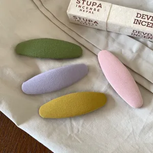 Gedetailleerd overzicht van kleurrijke stoffen ovale haarspelden, zacht dagelijks ontwerp.