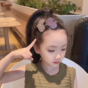 Close-up detail of sparkling rhinestone heart hair clips for kids, cute and shiny hair accessory.