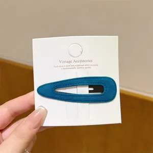Detail view of a stylish velvet BB hair clip in teal blue, showcasing fine texture and neat finish.