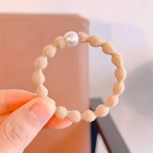 Simple basic bean hair tie detail view, elastic rubber band with single white pearl decor.