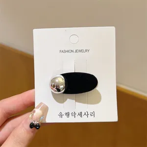 Zwarte fluwelen haarspeld met zilveren bal detail op displaykaart voor vrouwen haaraccessoire