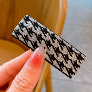 Κοντινή λεπτομέρεια μαύρο ασημί ύφασμα houndstooth κλιπ μαλλιών για καθημερινή χρήση.