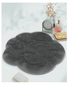 Detailed view of the grey paw-shaped silicone foot scrubber mat with dense massage bristles.