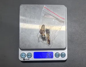 Vue détaillée de l'accessoire boucle de taille papillon jean présenté sur une balance.