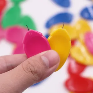 Close-up detail shot of colorful plastic needle threader with metal hook, easy sewing tool.