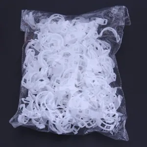 Détail en gros plan de clips de support de plante en plastique blanc dans un sac transparent.