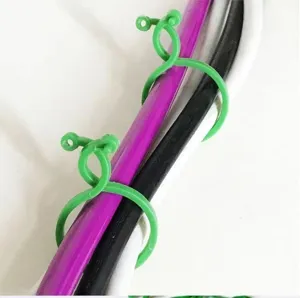 Green plastic figure-8 plant clips for garden climbing support and cable management detail.