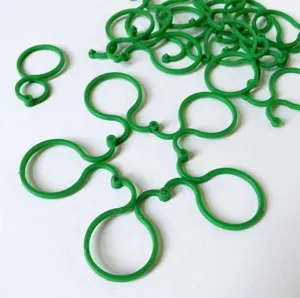 Green plastic figure 8 plant clips, flexible vine support rings for climbing vegetables and tomatoes.