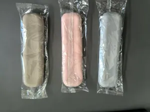 Detail view of portable silicone makeup brush storage cases in three colors with clear wrapping.