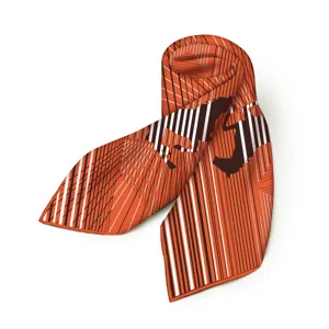 Detailaufnahme des orangen Seidenschals mit eleganten geometrischen Linien und Pferdemotiven.