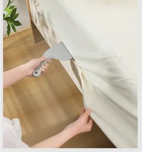 Detail view showing the bed sheet tucking tool in use, effortless gap stuffer for neat bedding.