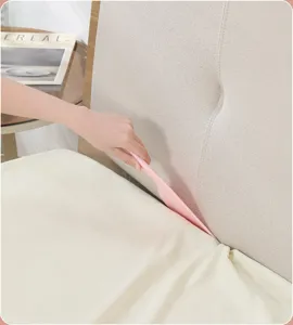 Detail view of the pink plastic bed sheet tucking tool used in setting sheet into gap.
