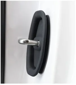 Close-up view of black silicone car door lock protector installed on white vehicle door.
