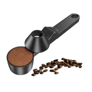 Cuillère à café noire en plastique durable avec tasseur intégré et fonction de mesure.
