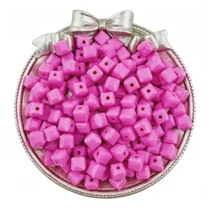 Close-up of pink acrylic cube beads in a decorative silver tray, ideal for DIY jewelry crafting.