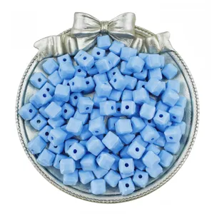 Detailed shot of light blue acrylic cube beads in a silver tray for DIY handmade jewelry.