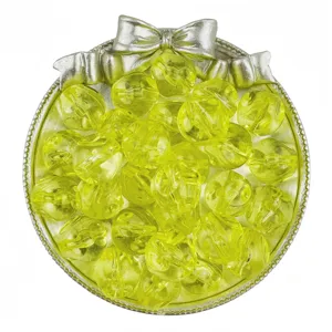 Detailed shot of vibrant yellow translucent acrylic beads in a decorative silver tray.