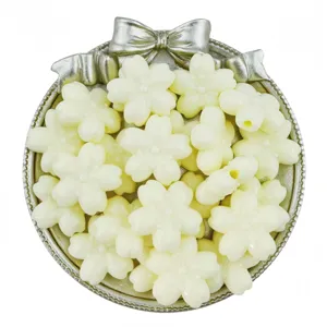 Close-up detail of cream white acrylic cherry blossom beads in a silver tray for DIY crafts.