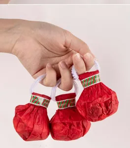 Primo piano sul dettaglio dello spara coriandoli portatile con confezione rossa e manico bianco.