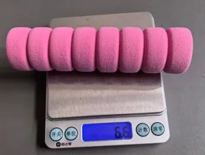 Pink foam door handle cover detail showing segmented texture and weight measurement on scale.