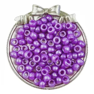 Primo piano dettagliato di perline a barilotto perlate viola, perfette per trecce di capelli.