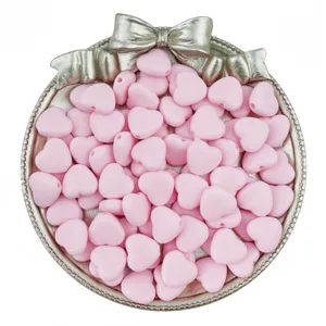 Detail shot of 9-12mm pink acrylic heart loose beads with vertical holes for DIY bracelet making.