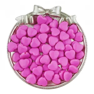 Detailed view of pink acrylic heart beads with vertical holes, perfect for DIY jewelry and crafts.
