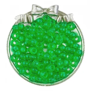 Close-up detail of transparent green barrel pony beads arranged neatly in a silver bow tray.
