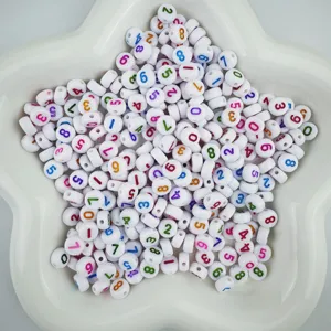 Primer plano de cuentas acrílicas con números de colores en plato estrella, detalles de abalorios.