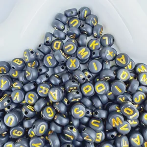 Close-up detail of black and gold acrylic letter beads, perfect for custom DIY friendship bracelets.