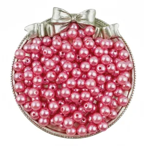 Detailed view of pink ABS imitation pearl beads in a decorative bow tray for DIY jewelry.