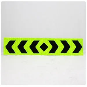 Reflective safety tape detail shot showing black arrows on fluorescent green background.
