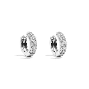 Close-up detail of sparkling pave set huggie hoop earrings, featuring brilliant crystal stones.