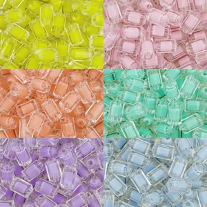 Gros plan sur les détails des perles cylindriques en acrylique colorées pour bijoux DIY.