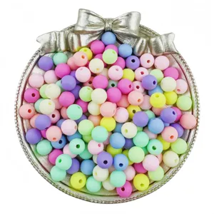 Close-up of colorful frosted round beads with straight holes in silver bow tray for DIY jewelry.