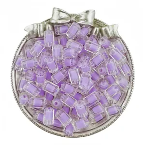 Gros plan sur des perles cylindriques en acrylique mauve de 12mm pour la création de bijoux DIY.