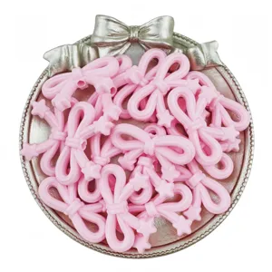 Detailed shot of pink acrylic star bow beads arranged in a decorative silver tray for DIY handmade jewelry.