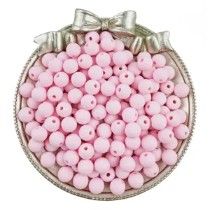 Close up of pink frosted acrylic round beads with straight holes, perfect for DIY jewelry craft details.