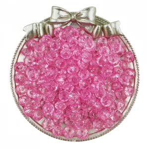 Gros plan détaillé de perles rondelles en acrylique rose translucide dans un plateau argenté.