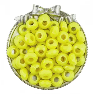 Gros plan de perles d'acrylique facettées jaunes dans un plateau décoratif argenté en nœud.