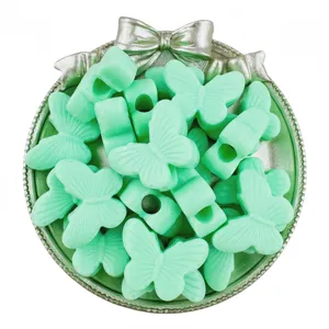 Close-up of mint green acrylic butterfly large hole beads for DIY jewelry accessories.